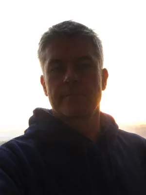A man whose face is in shadow against a bright sky